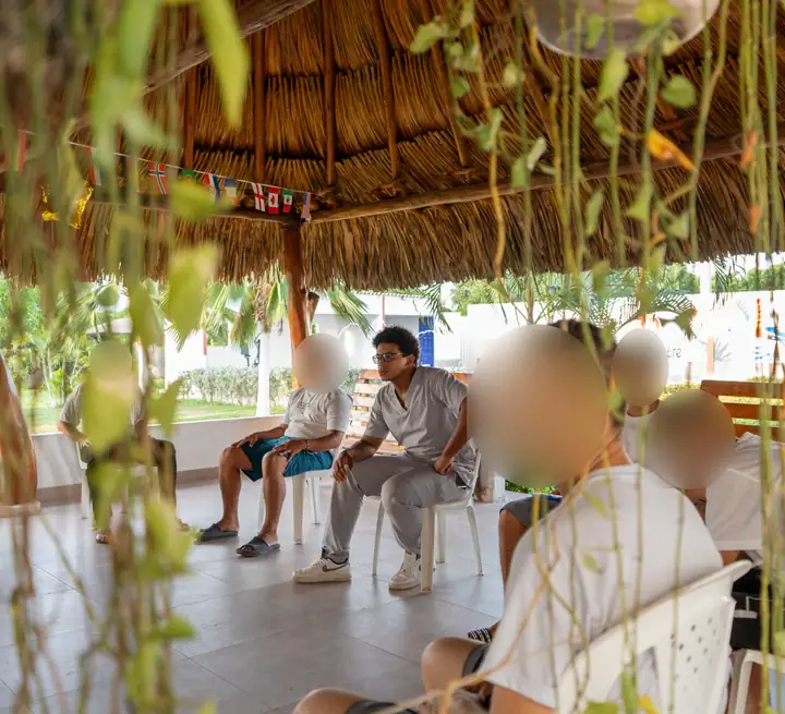 Sesión bajo el bohío, vista entre plantas colgantes