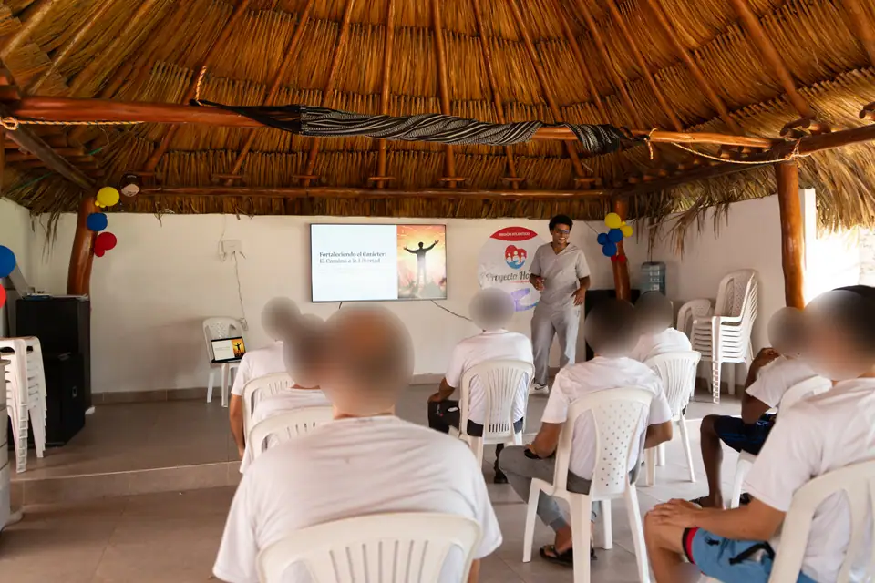 Charla con presentación en pantalla bajo el bohío