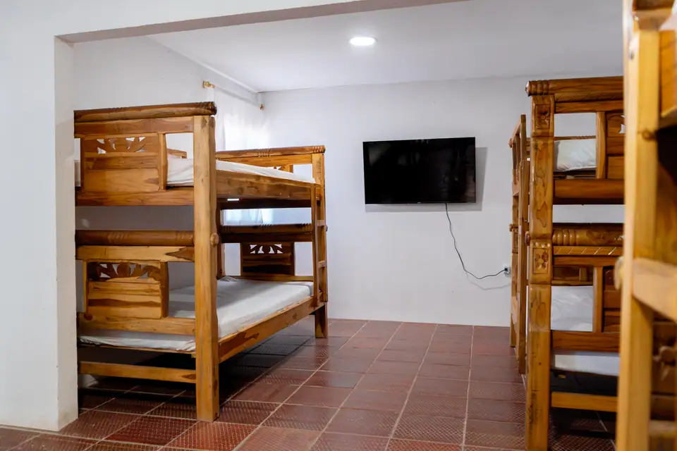 Habitación con camarotes de madera y un televisor
